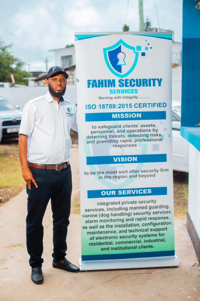 Fahim Security staff member by the company banner